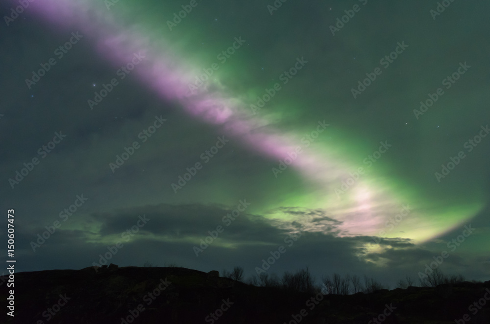 The Aurora and clouds in the sky above the hills . The Aurora and clouds in the sky above the hills .