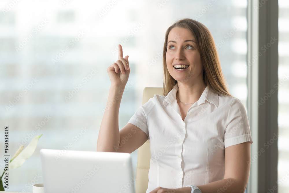 Surprised woman sitting at desk in front of laptop with raised forefinger. Female entrepreneur found life hack unexpected problem solution, has great idea. Businesswoman remembered something important Surprised woman sitting at desk in front of laptop with raised forefinger. Female entrepreneur found life hack unexpected problem solution, has great idea. Businesswoman remembered something important