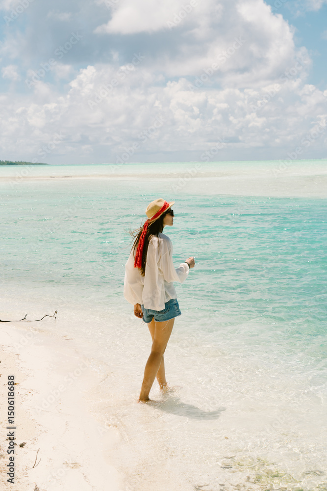 Woman walking along beach, looking at view, Tahiti, South Pacific Woman walking along beach, looking at view, Tahiti, South Pacific