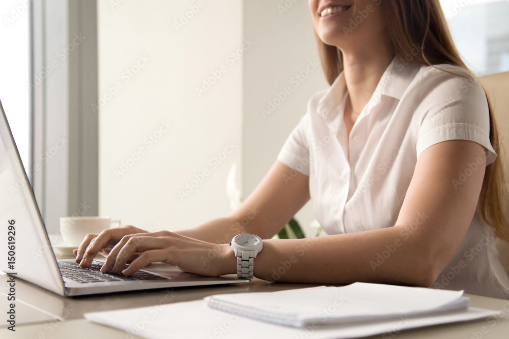Close up photo of womans hands typing on laptop. Smiling woman working on computer. Female office worker doing daily routine. Workplace ergonomics and correct posture, tunnel syndrome prevention