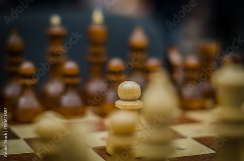 Classical wooden chess. Focus on the pawn in the middle of the board.