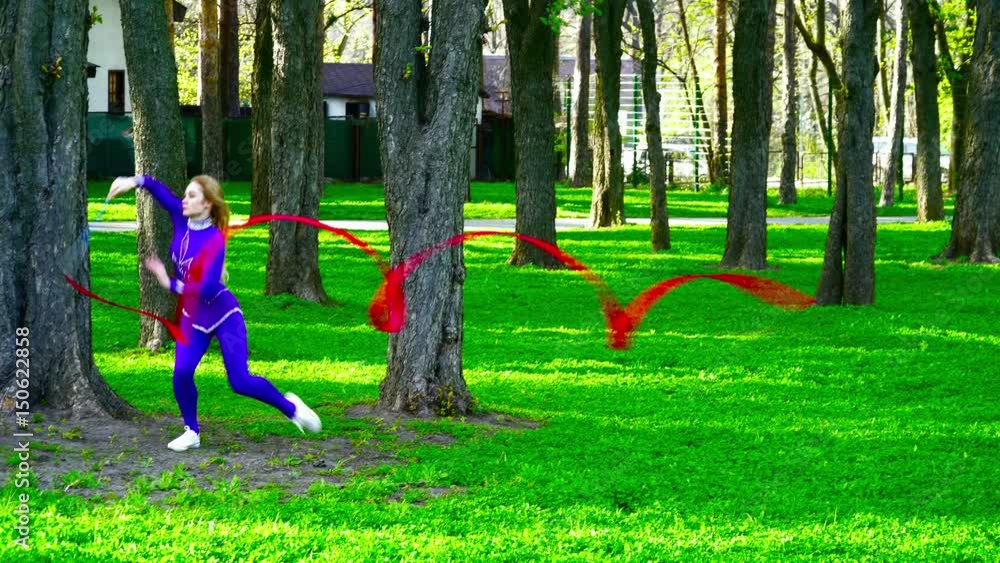 Young gymnast dacing with the ribbon in the park Young gymnast dacing with the ribbon in the park