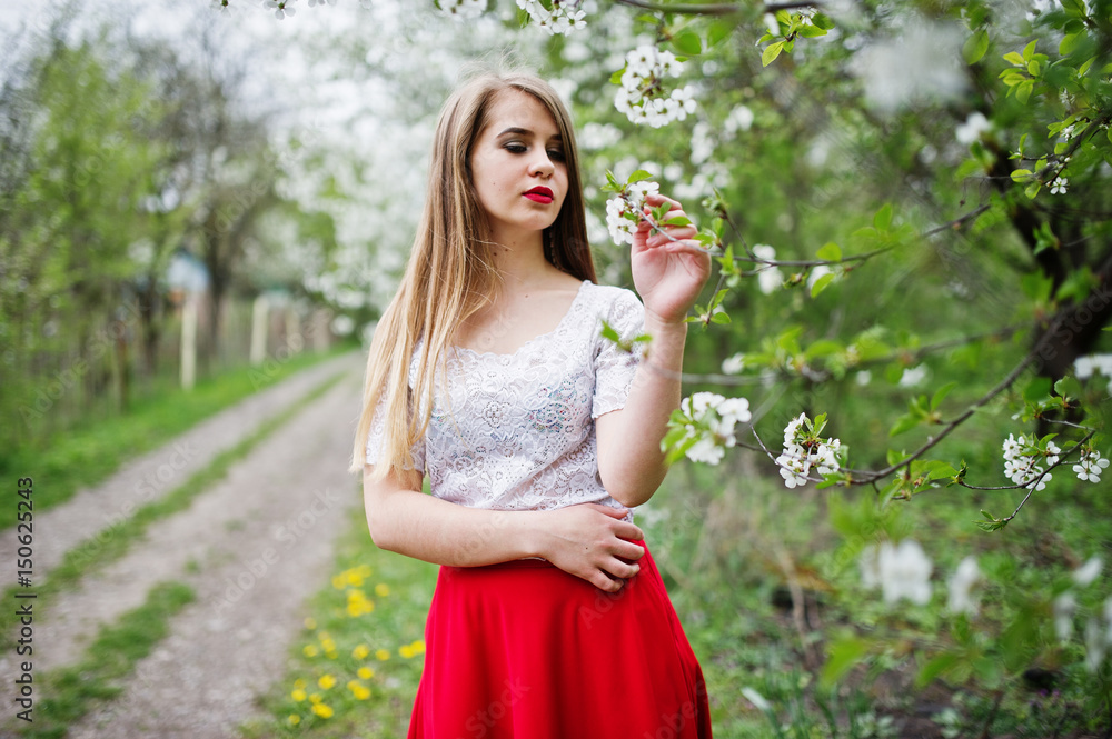 Portrait of beautiful girl with red lips at spring blossom garden, wear on red dress and white blouse. Portrait of beautiful girl with red lips at spring blossom garden, wear on red dress and white blouse.