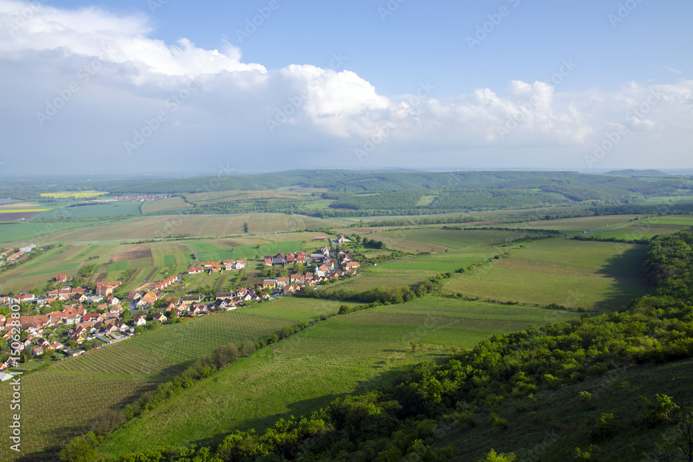 View of the village of Pavlov and the vineyards and fields in the area of Palava - South Moravia under a blue sky with clouds View of the village of Pavlov and the vineyards and fields in the area of Palava - South Moravia under a blue sky with clouds