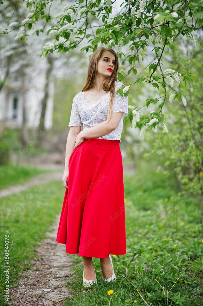 Portrait of beautiful girl with red lips at spring blossom garden, wear on red dress and white blouse. Portrait of beautiful girl with red lips at spring blossom garden, wear on red dress and white blouse.