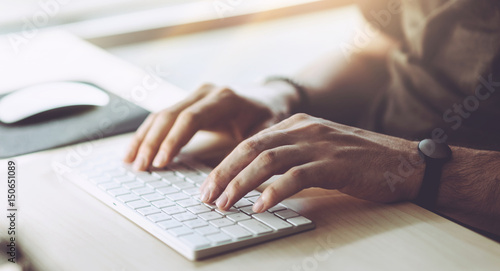 Wallpaper Mural Coworker working at sunny office at work place, Man using desktop computer at home while sitting the wooden table. Torontodigital.ca