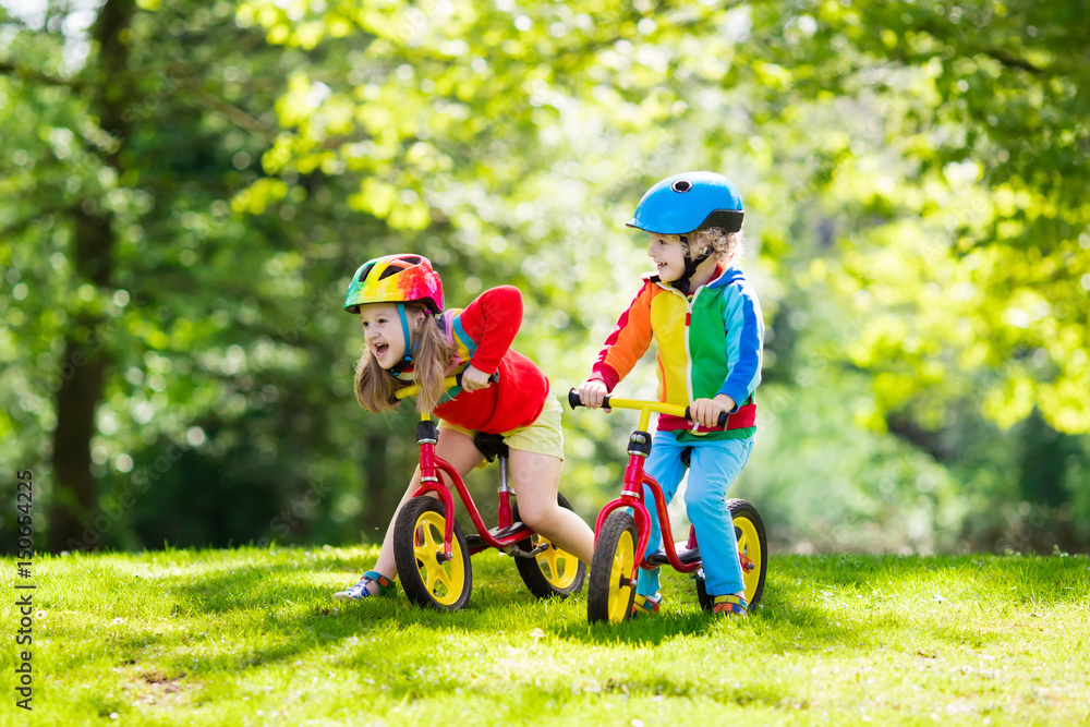 Kids ride balance bike in park Kids ride balance bike in park
