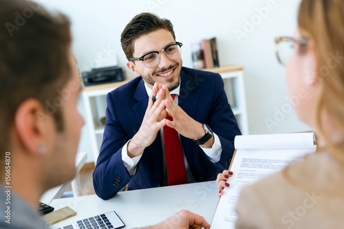 Business man explaining terms of contract to his clients in the office.