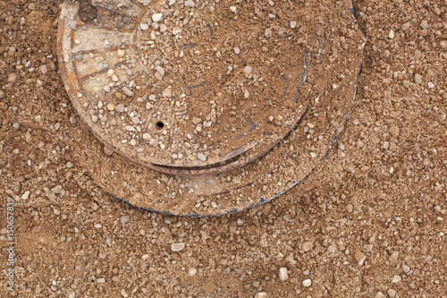 The collector hatch is sprinkled with sand. The manhole at the construction site is filled with sand.