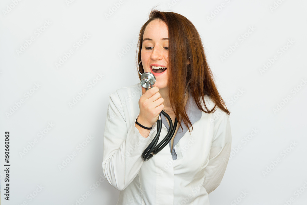 Young female doctor with singing in a stethoscope, isolated on white background Young female doctor with singing in a stethoscope, isolated on white background