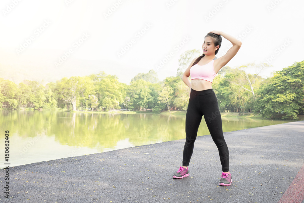 young sport woman warming and stretching on road in the garden young sport woman warming and stretching on road in the garden