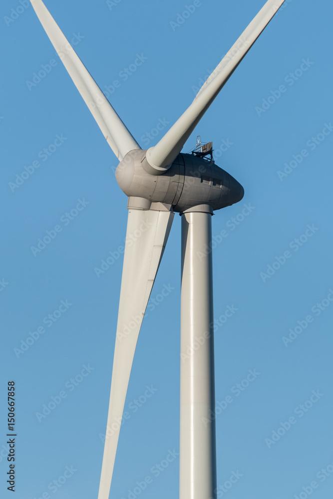 Close up of a wind turbine against a blue sky. Close up of a wind turbine against a blue sky.