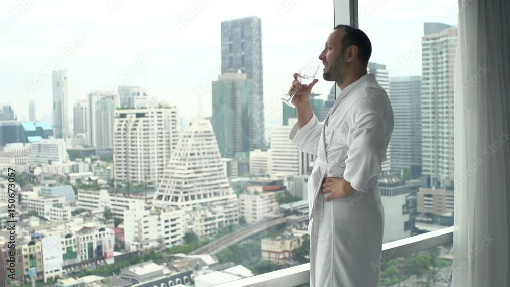 Young man in bathrobe drinking wine by window at home, super slow motion 120fps
Young man in bathrobe drinking wine by window at home, super slow motion 120fps