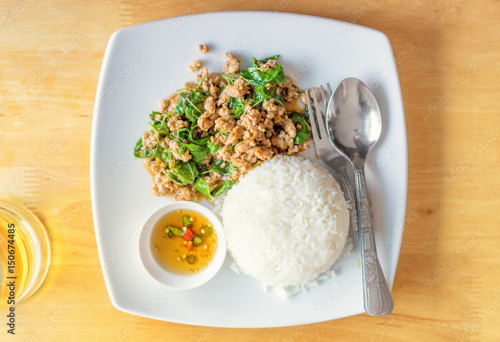 Pad Kaprao Thai traditional dish, fried meat with a basil sauce on a plate, top view Pad Kaprao Thai traditional dish, fried meat with a basil sauce on a plate, top view