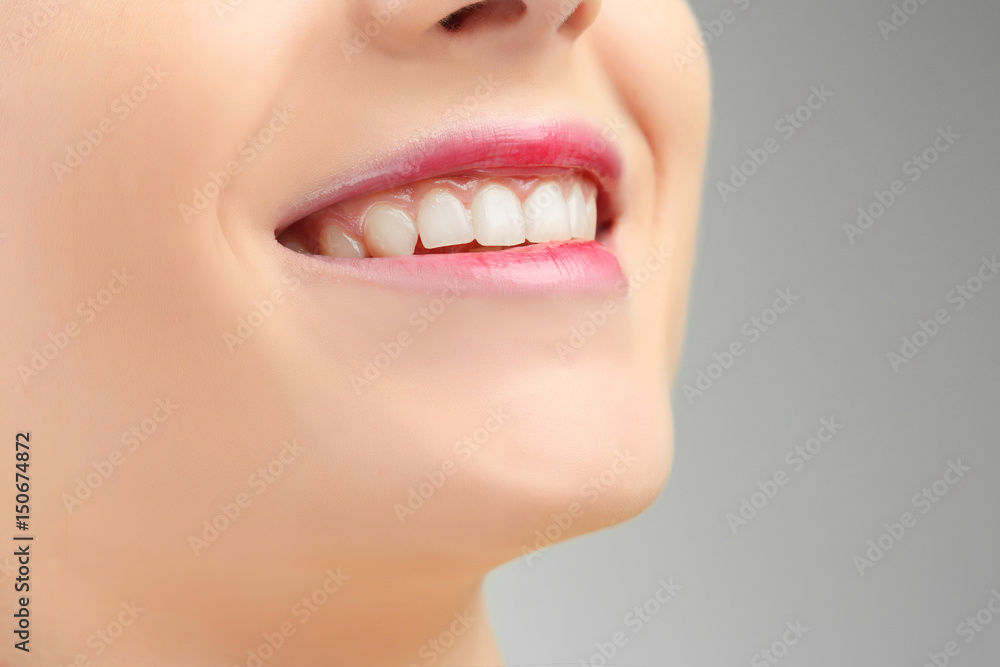 Face of beautiful young woman on grey background, closeup Face of beautiful young woman on grey background, closeup