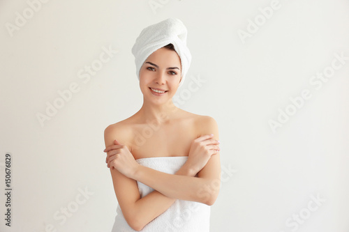 Beautiful young woman after shower on light background