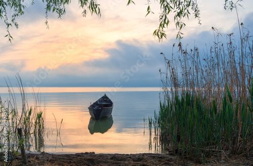 Photo Old rowboat on the lake at sunset
