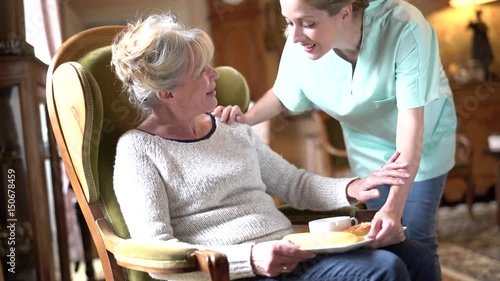 Nurse bringing breakfast to senior female patient  photo