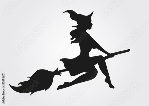 Silhouette of a witch flying on a broomstick photo