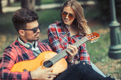 Happy Couple at the Park Playing Guitar and Singing Songs.