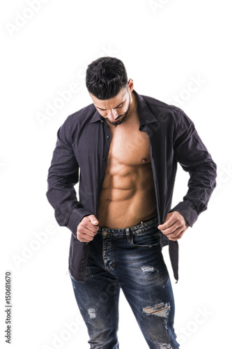 Muscular bodybuilder undressing, opening shirt on naked muscle torso, isolated on white background