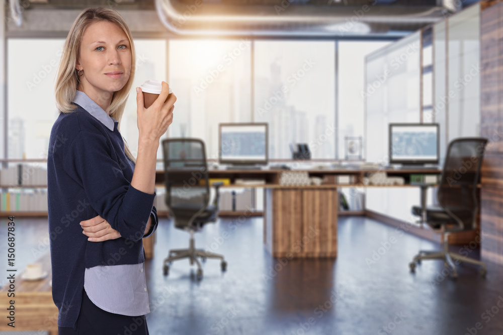 Portrait of young happy smiling business woman enjoying coffee break at work