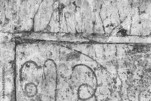 Obraz na płótnie Weathered and aged grey concrete wall with some faded Burmese writing in black&white