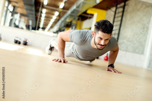 handsome young man doing push ups at the gym. Self motivation. Persistence in practice.