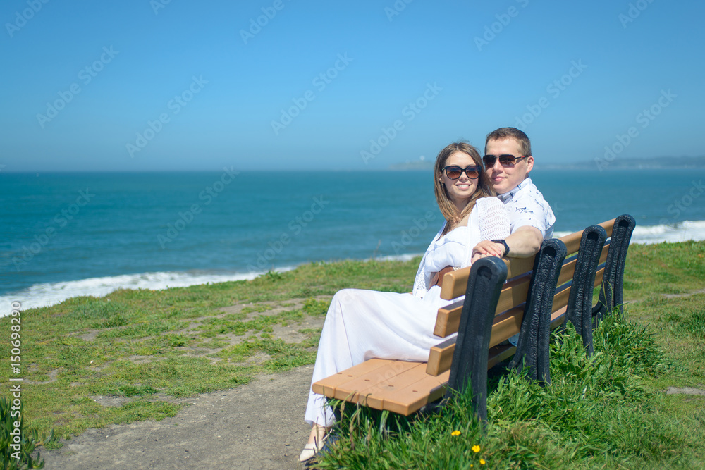 Young romantic couple in sunglasses on the beach