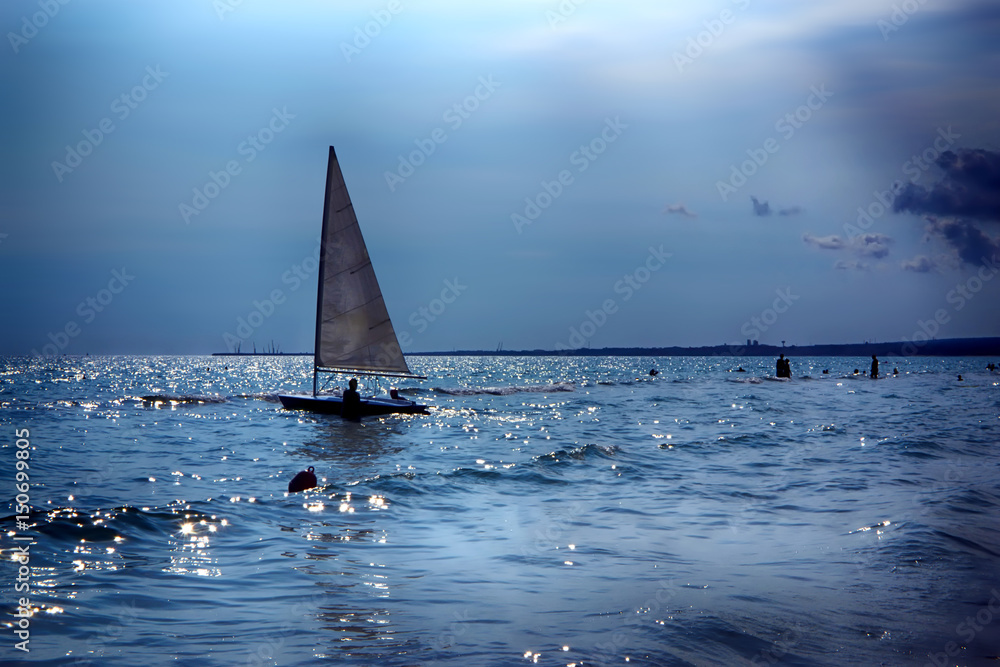 Piccola imbarcazione con vela in mezzo al mare