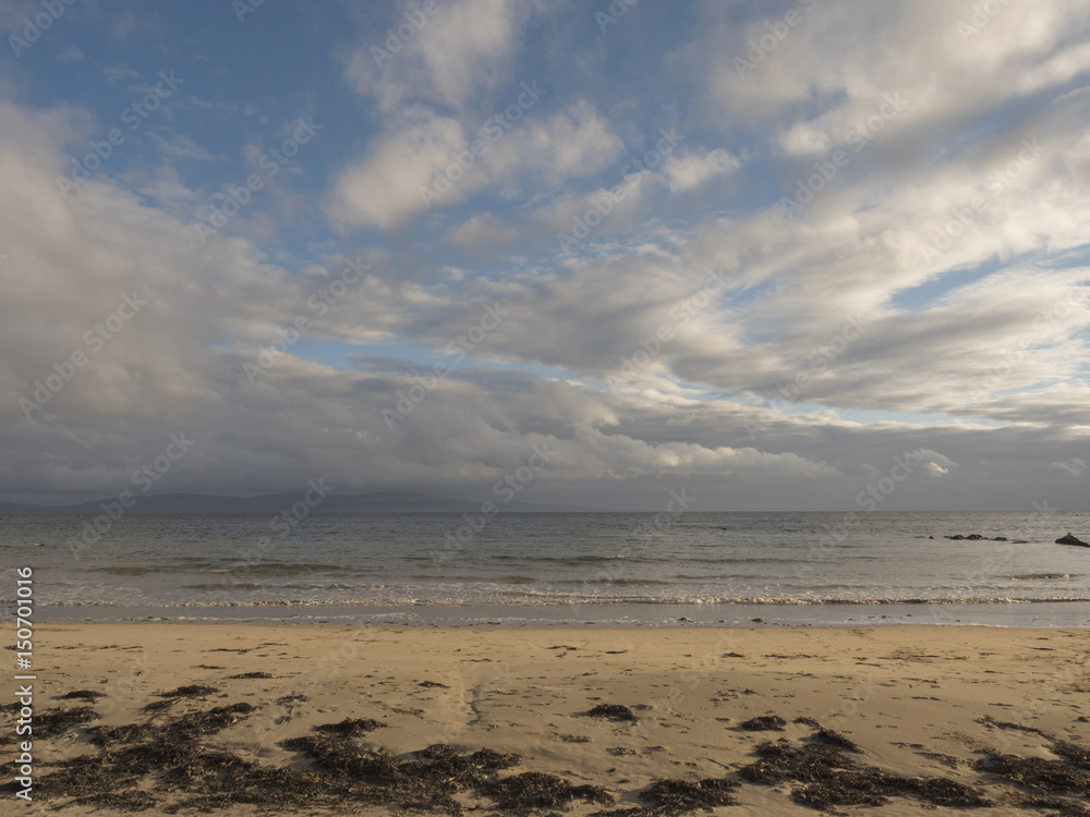 Clouds over ocean and sandy beach with sea weed, Clouds over ocean and sandy beach with sea weed,