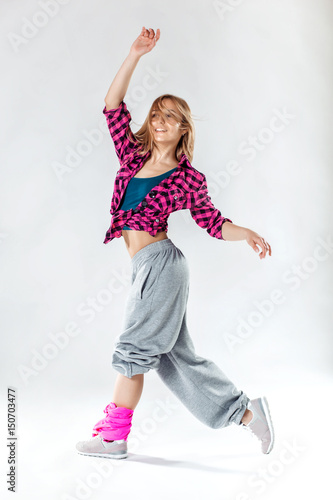 Young beautiful slim girl dancing on a white studio background
