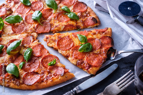 Homemade Pepperoni Pizza over black background. Top view.