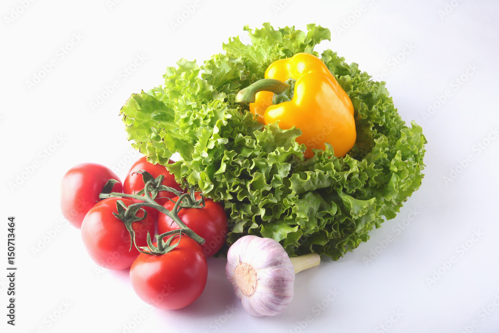Fresh assorted vegetables bell pepper, tomato, garlic with leaf lettuce. Isolated on white background. Selective focus. Fresh assorted vegetables bell pepper, tomato, garlic with leaf lettuce. Isolated on white background. Selective focus.