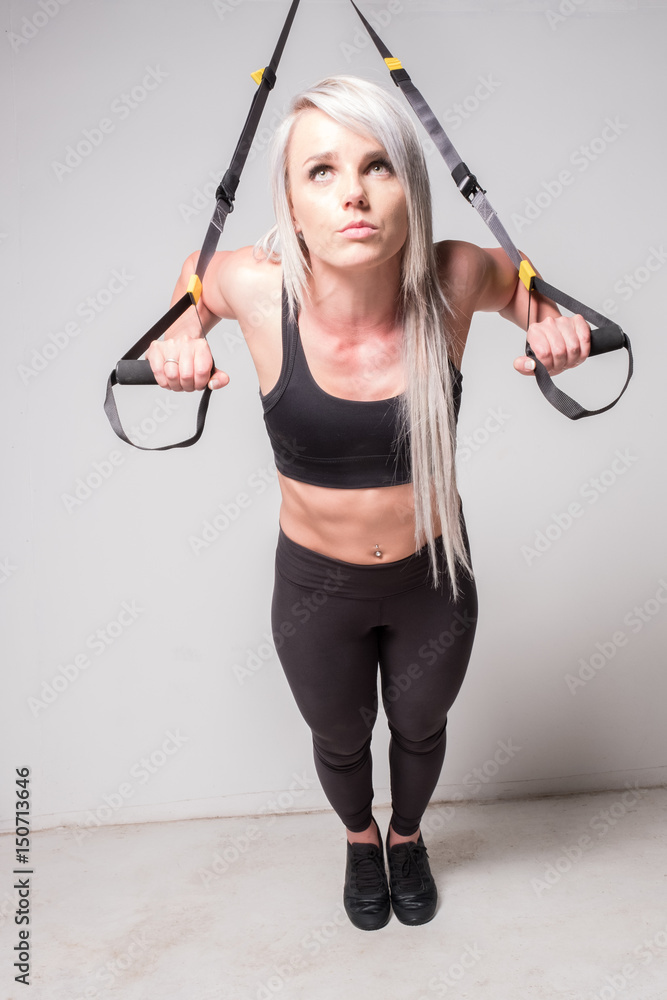 female using a suspension trainer female using a suspension trainer