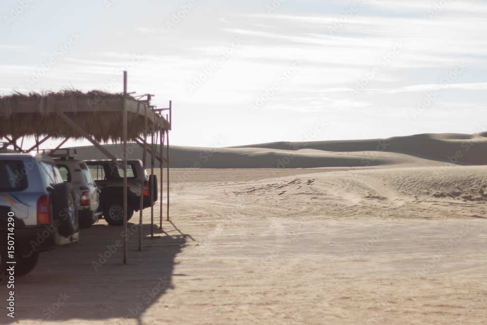 Tourist jeep under the roof in the desert. Safari walks through the dunes