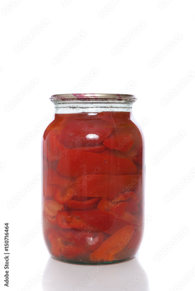 Canned red pepper in a glass jar on a white background. Canned red pepper in a glass jar on a white background.
