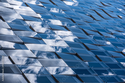Reflections of cloudy sky on a glass facade