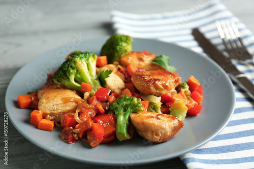 Chicken stir fry with vegetables and cutlery on table