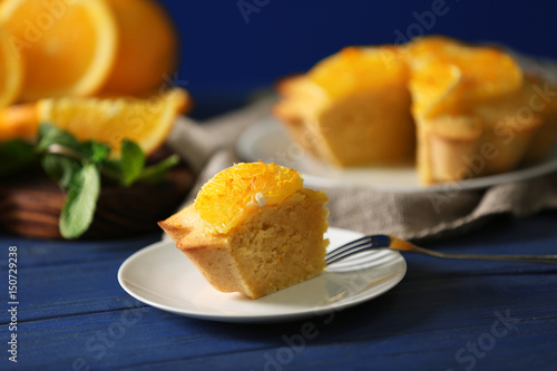 Plate with delicious citrus cake on wooden table