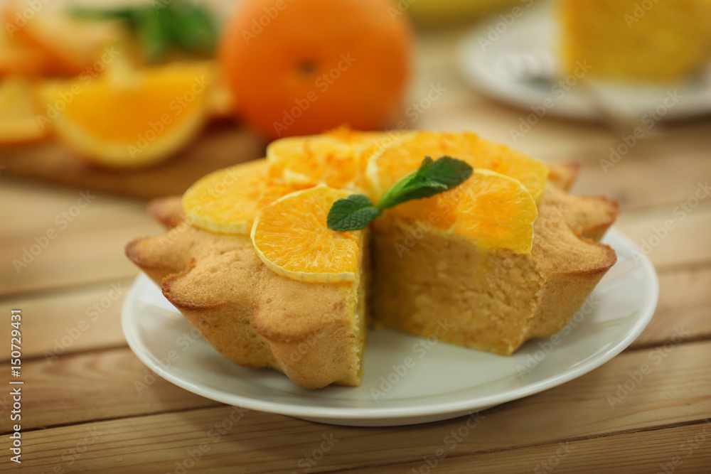 Plate with delicious citrus cake on wooden table Plate with delicious citrus cake on wooden table