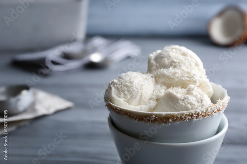 Serving cups with balls of coconut ice cream on grey table