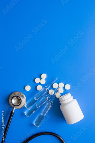 doctor's instruments and meds in medical set on blue background space for text