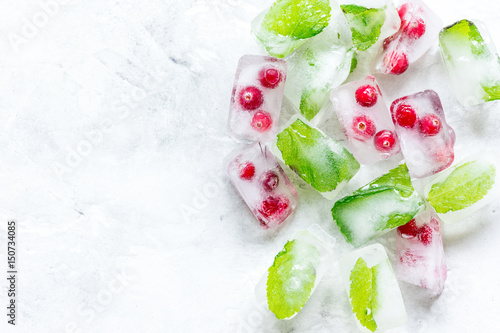 mint and red berries in ice cubes stone background top view mockup #150734085