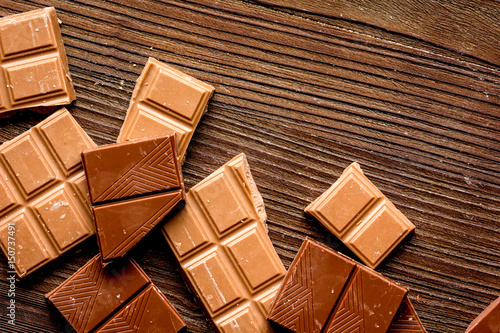 black and milk chocolate bars with mint dark wooden table background top view mock-up