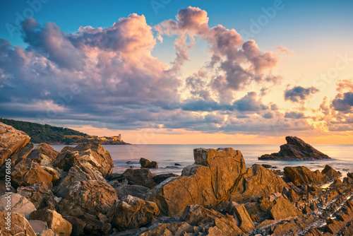 Rocks and buildings on the sea at sunset. Livorno, Tuscany riviera, Italy photo