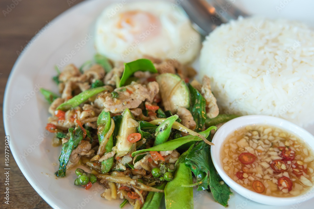 Rice topped with stir-fried pork and basil with Sunny Side Up Rice topped with stir-fried pork and basil with Sunny Side Up