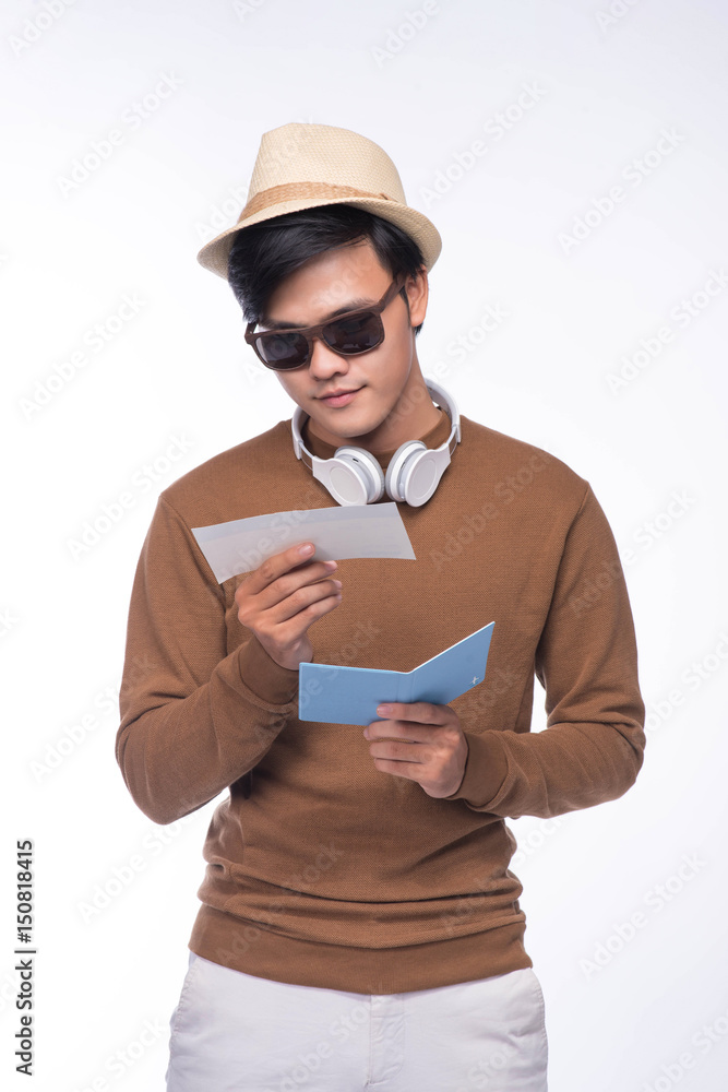 Happy asian male tourist holding passport over grey background Happy asian male tourist holding passport over grey background