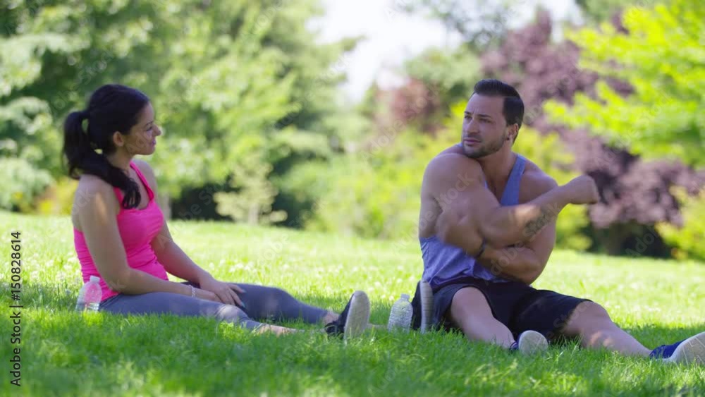 Athletic couple at park stretching before run Athletic couple at park stretching before run