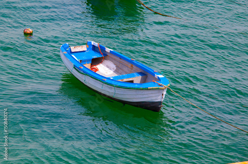 Boat on calm sea  in Cascais Bay, Cascais, Portugal © Kalnenko